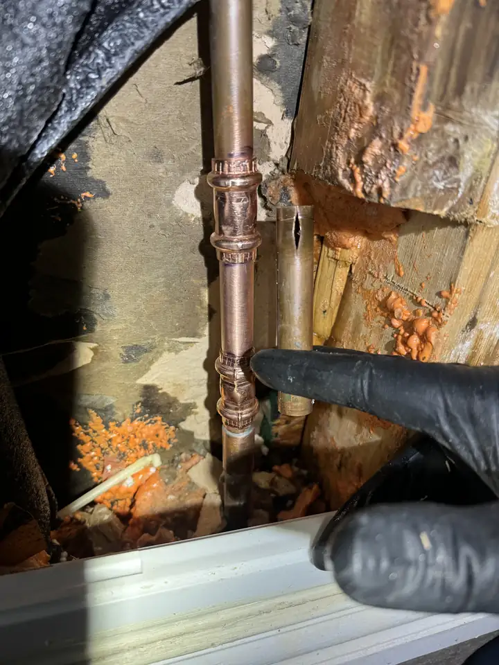 New copper section with couplings on the water line to an outside spigot inside an opened garage wall after a freeze, Frisco
