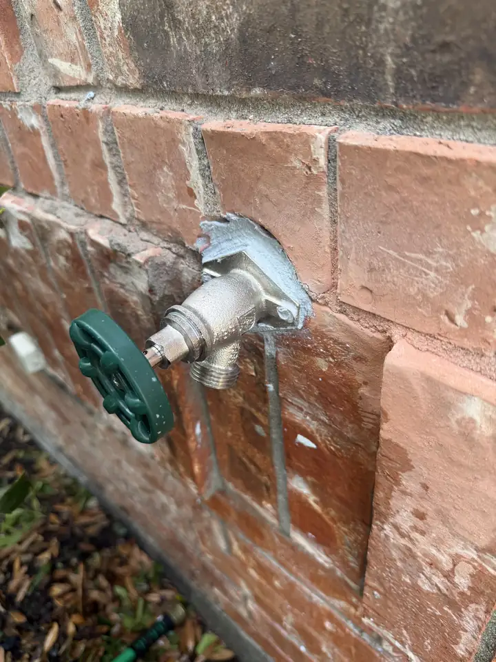 New frost free outside faucet on a brick wall, Frisco
