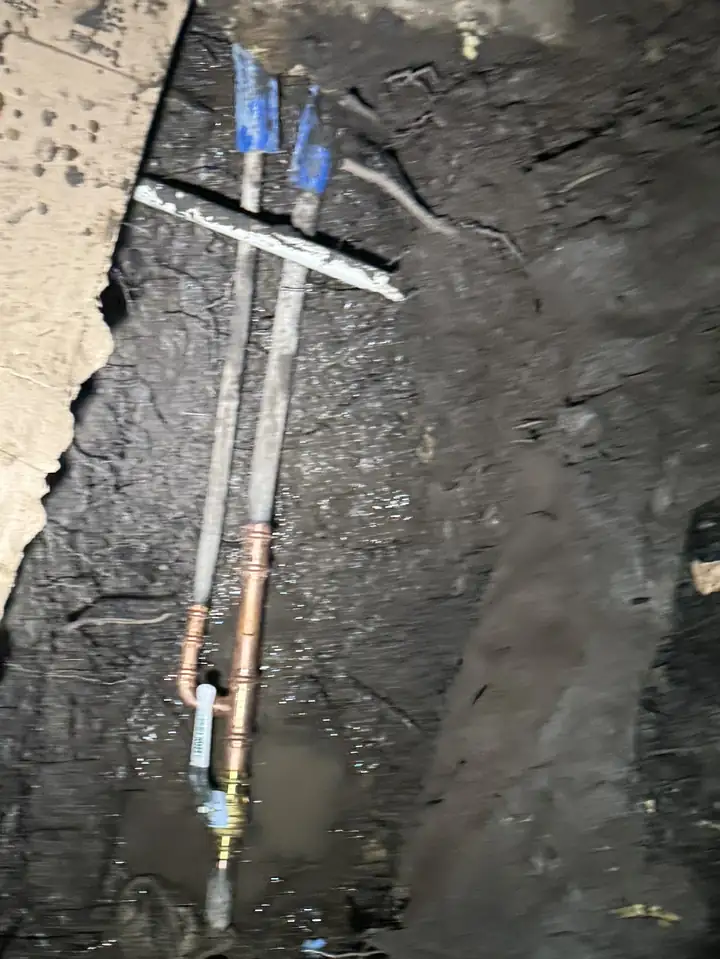 New copper main water line section with a shut-off valve in a dig next to a house wall, Plano