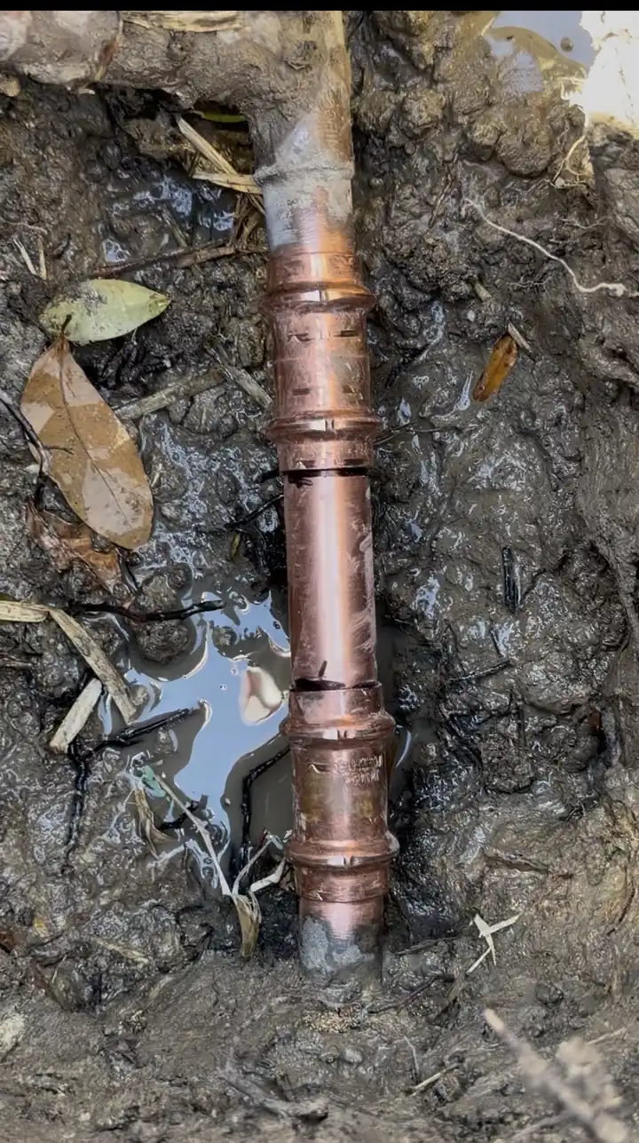 Main water line repaired with a short ProPress copper section in a yard dig