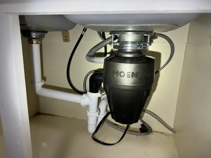 New Moen 3/4 HP garbage disposal installed under a sink, Plano