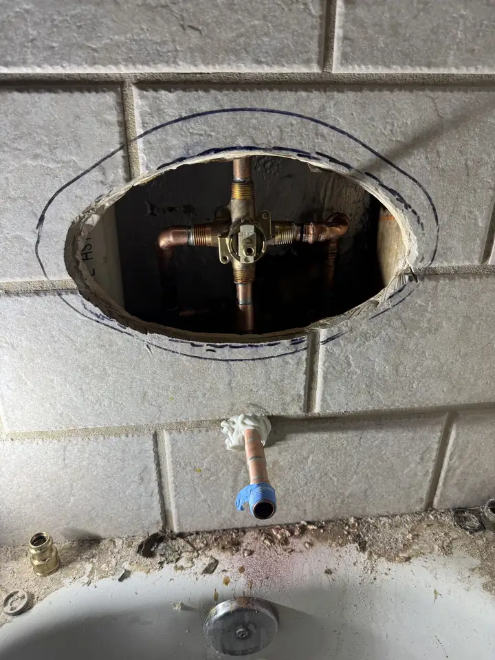 New single handle Moen shower valve soldered in through a small tile opening, McKinney