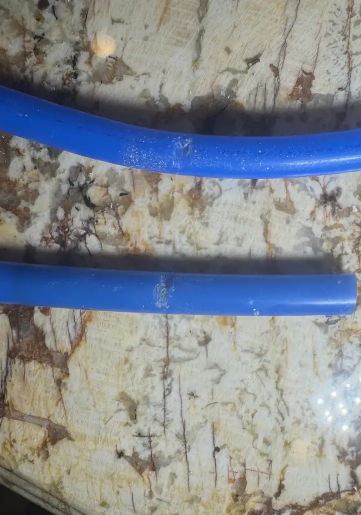Two cut out pieces of blue PEX water line from an attic, chewed through by rodents, Allen