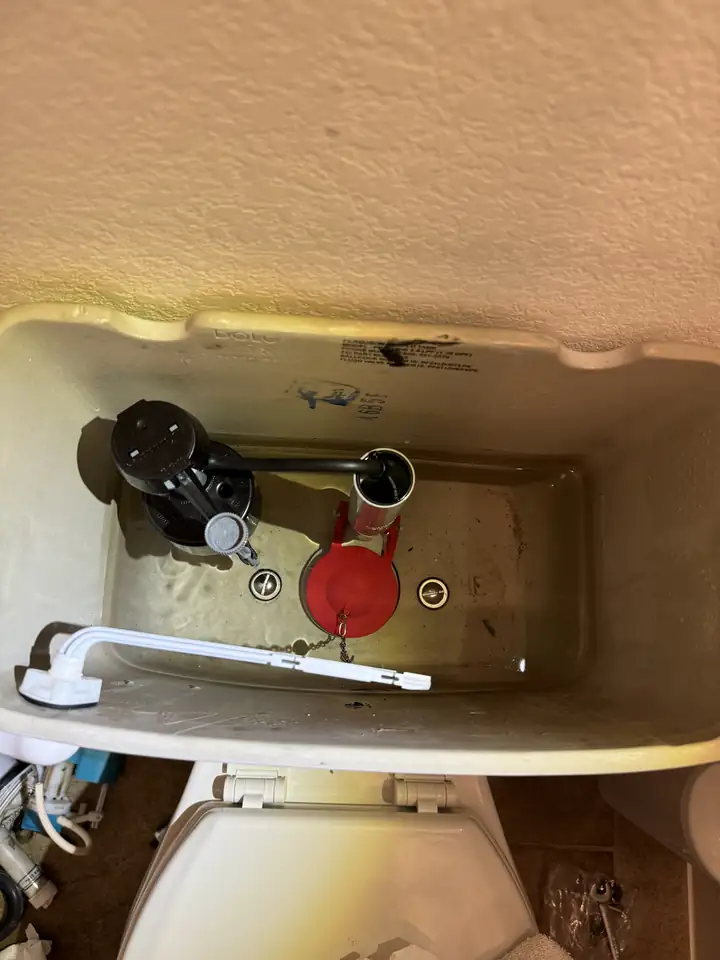 Toilet tank with new fill valve and flush valve installed, McKinney