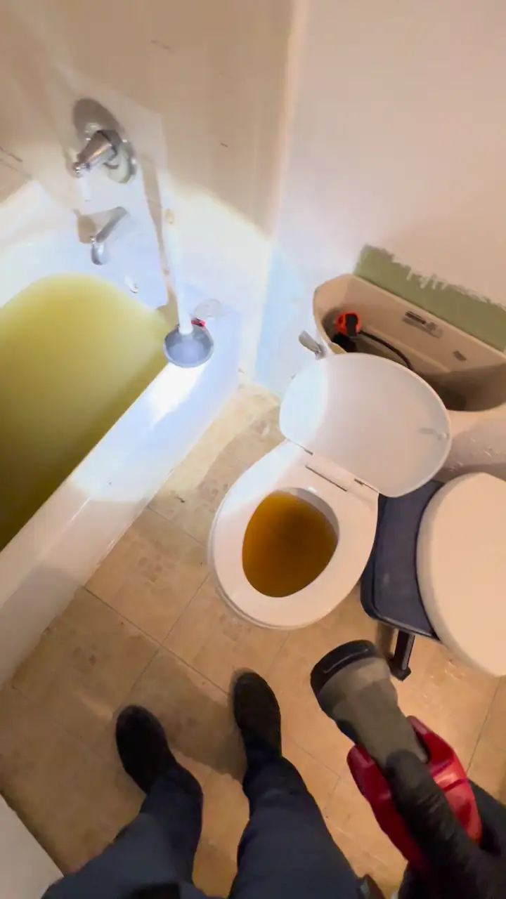 Bathtub and toilet full of backed up sewage water from a clogged main sewer line