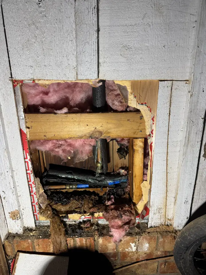 Burst pipe inside an opened wall before removal