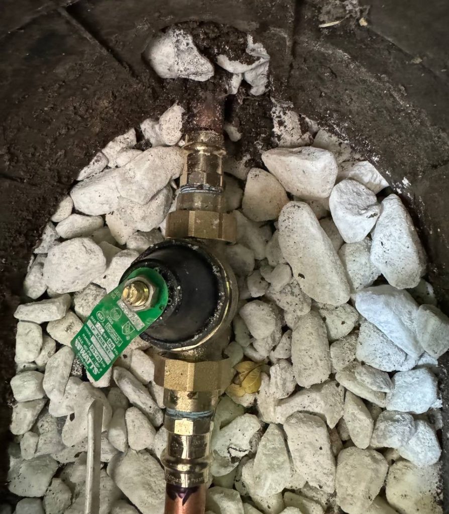 Newly installed PRV valve set in ground near water meter during outdoor plumbing in Lewisville, TX