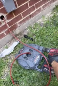 Clearing a clogged kitchen drain through an outside cleanout using a RIDGID chain snake