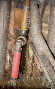 Copper hot water line with repair fitting at the slab foundation after two slab leaks in Plano TX